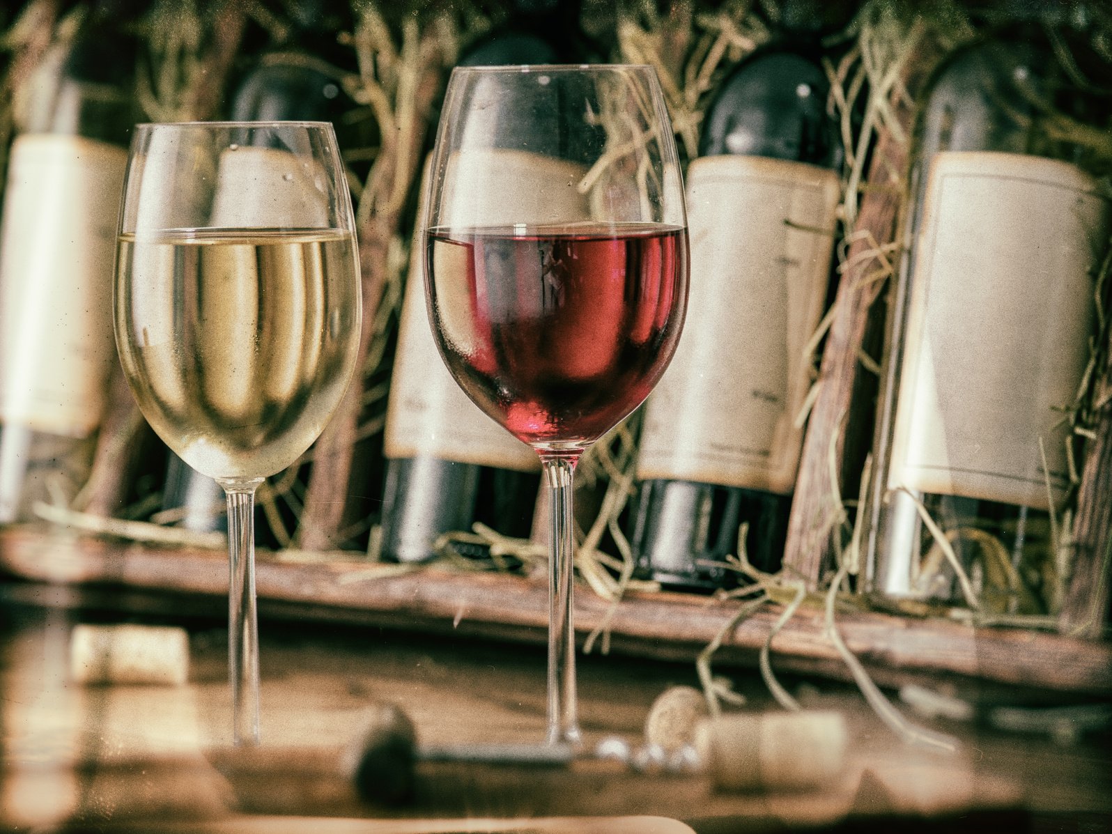 Wine testing at the storage. Glass of wine and wine bottle in the wine cellar. Vintage style.